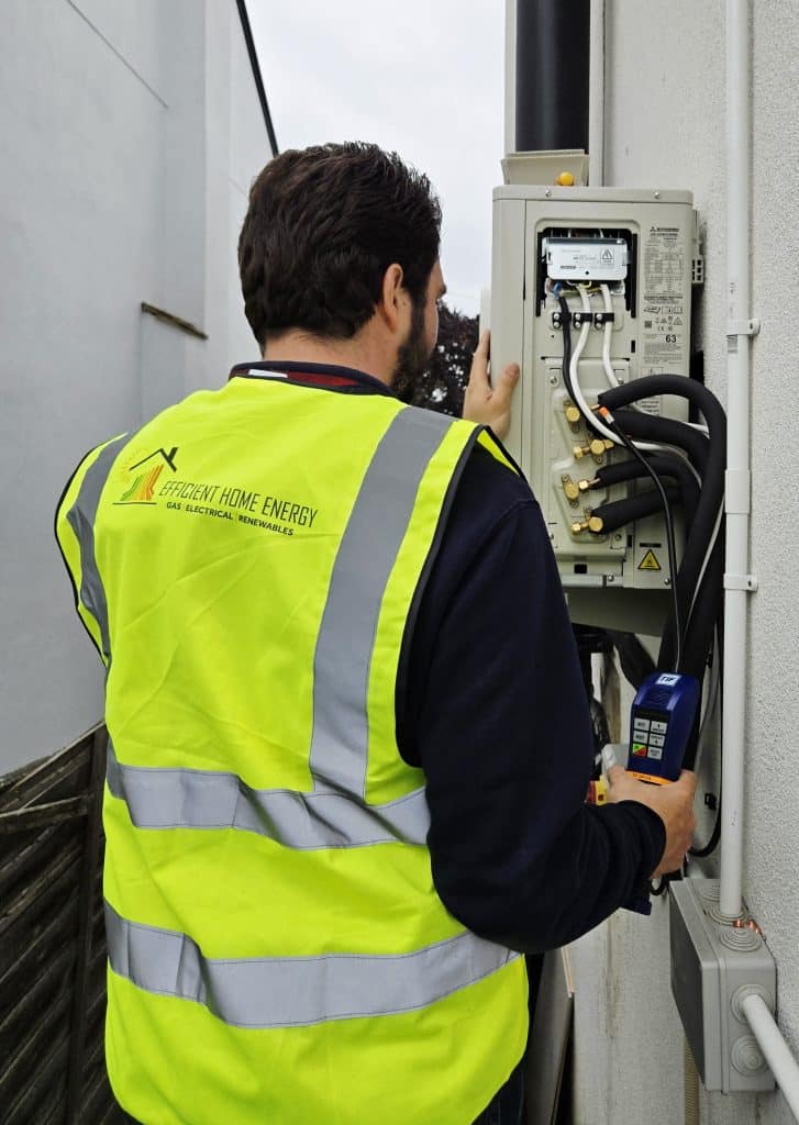 A picture of an engineer installing an air conditioning external unit